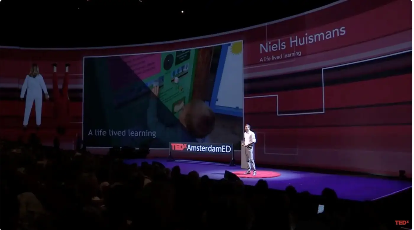 Niels Huismans op het podium van TEDxAmsterdamED tijdens de talk 'A life lived learning'